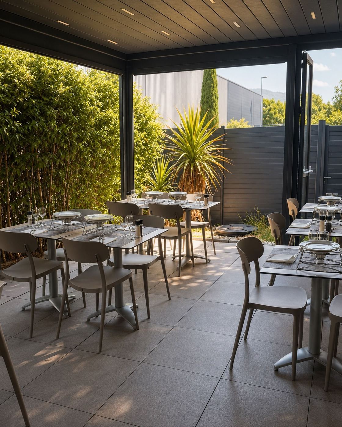 Terrasse couverte et végétalisée du Bistro Régent Aubagne, avec les tables dressées